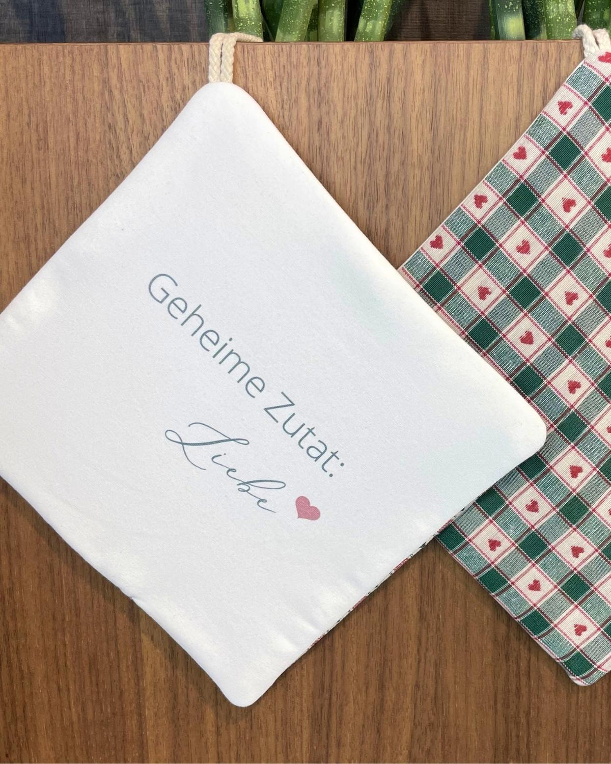 Topflappen mit Aufdruck „Geheime Zutat Liebe“ und grün-rotem Herzmuster